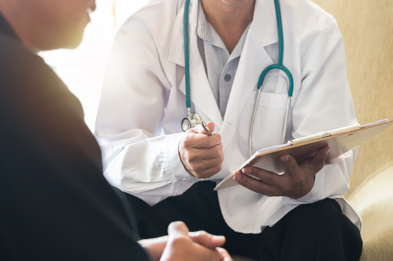 Doctor and patient facing each other during GP appointment